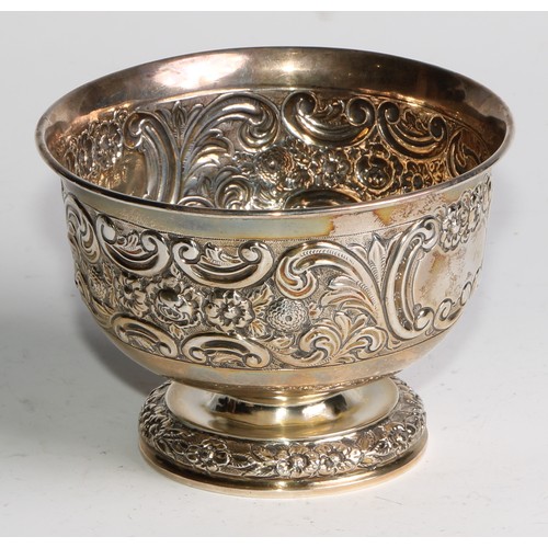 1037 - A pair of Victorian silver pedestal bowls, chased with flowers and scrolling leaves, centred by vaca... 