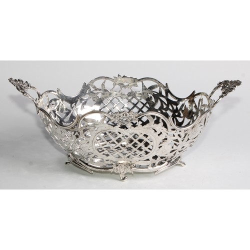 884 - A Dutch silver boat shaped cake basket, pierced and engraved with flowers, scrolling leaves, and tre... 