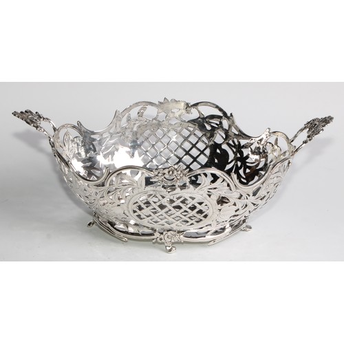 884 - A Dutch silver boat shaped cake basket, pierced and engraved with flowers, scrolling leaves, and tre... 