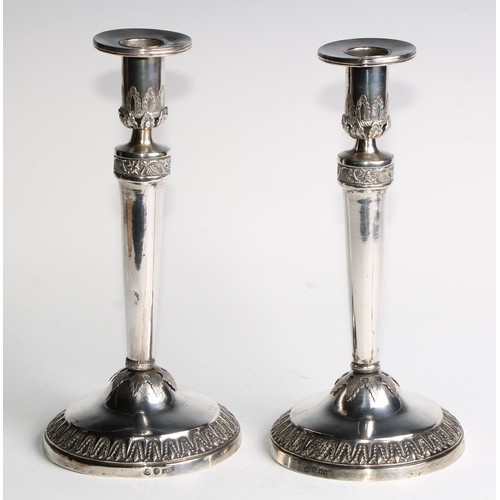 1014 - A pair of Continental silver circular table candlesticks, chased and applied with fruiting vine and ... 