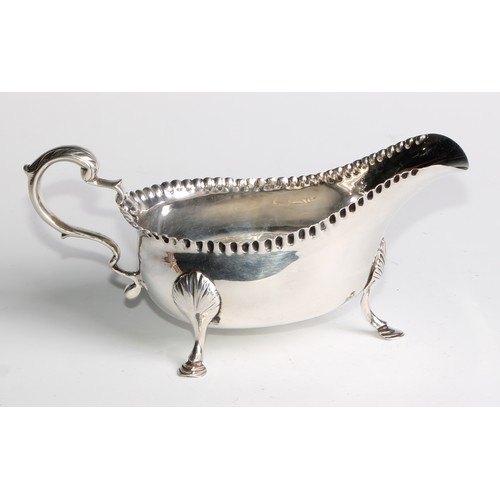 1119 - An 18th century Irish Provincial silver sauce boat, punch-beaded border, acanthus capped double-scro... 