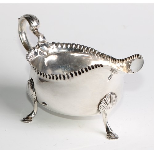 1119 - An 18th century Irish Provincial silver sauce boat, punch-beaded border, acanthus capped double-scro... 