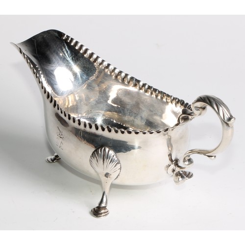 1119 - An 18th century Irish Provincial silver sauce boat, punch-beaded border, acanthus capped double-scro... 