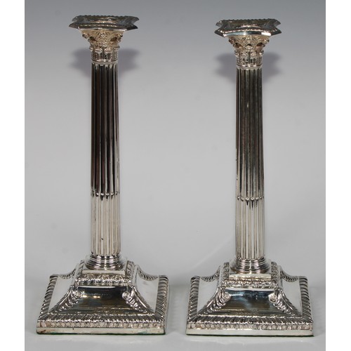 823 - A pair of George III Old Sheffield Plate stop-fluted Corinthian column candlesticks, beaded nozzles,... 