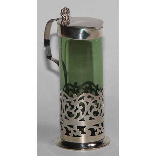 1018 - A pair of Edwardian silver mounted green glass liqueur jugs, hinged covers with anthemion thumb piec... 