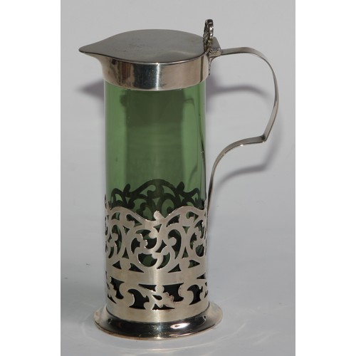 1018 - A pair of Edwardian silver mounted green glass liqueur jugs, hinged covers with anthemion thumb piec... 