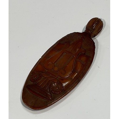 2132 - A 19th century coquilla nut scent bottle, carved with triumphant regalia and lyre, 7.5cm long, c.180... 