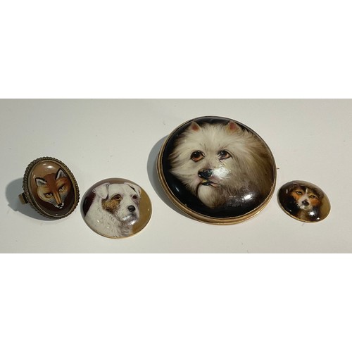 1412 - A mid-Victorian yellow metal-mounted enamel brooch, painted with the head of a West Highland Terrier... 