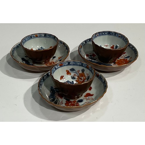 479 - A set of three Chinese Batavian tea bowls and saucers, the interiors decorated in underglaze red and... 