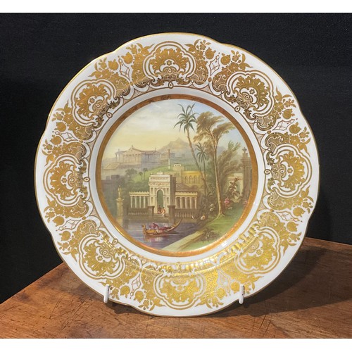 171 - A shaped circular cabinet plate, probably Coalport, the field painted with temples in an exotic moun... 