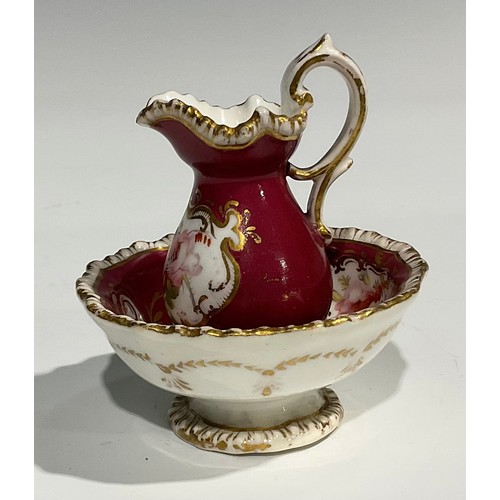 158 - An English porcelain miniature jug and bowl, probably Rockingham, painted with flowers on a green gr... 