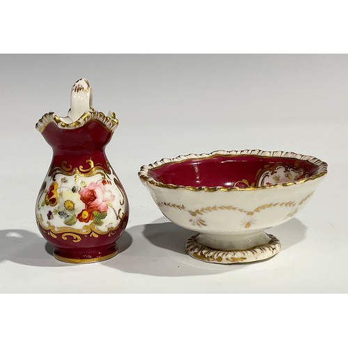 158 - An English porcelain miniature jug and bowl, probably Rockingham, painted with flowers on a green gr... 