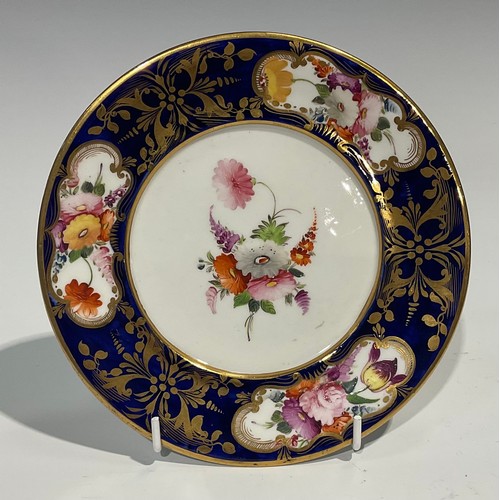 162 - An English porcelain shaped circular plate, the field painted with a basket of flowers and fruit on ... 