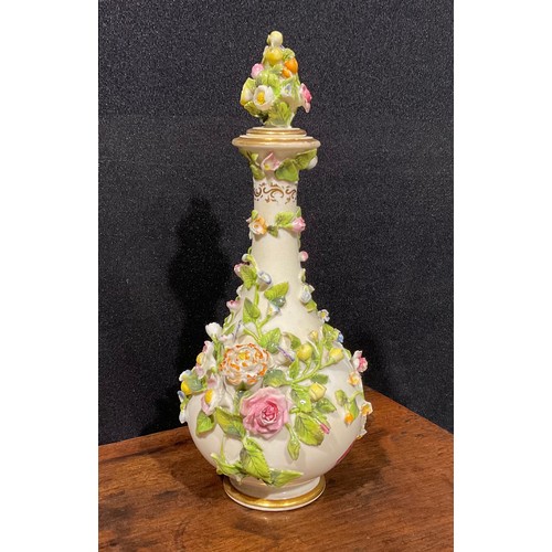 136 - A Rockingham bottle shaped decanter and stopper, profusely encrusted with flowers and foliage and pa... 