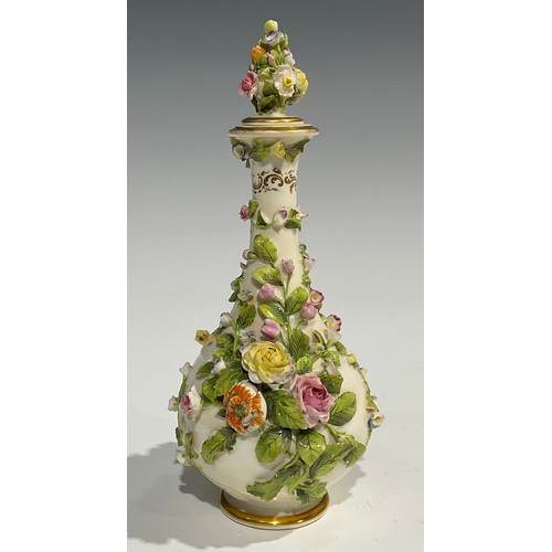 136 - A Rockingham bottle shaped decanter and stopper, profusely encrusted with flowers and foliage and pa... 