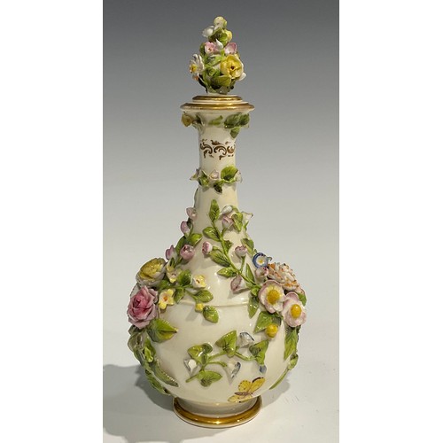 136 - A Rockingham bottle shaped decanter and stopper, profusely encrusted with flowers and foliage and pa... 