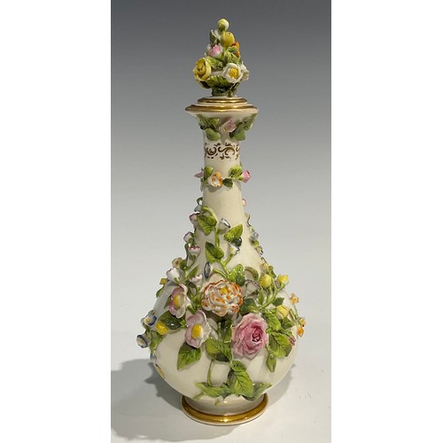 136 - A Rockingham bottle shaped decanter and stopper, profusely encrusted with flowers and foliage and pa... 