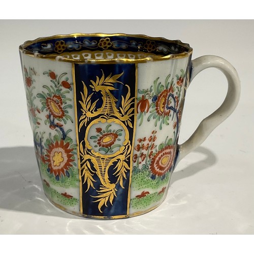 212 - A Worcester fluted teacup and saucer, painted with panels of colourful flowers on a green ground, bl... 