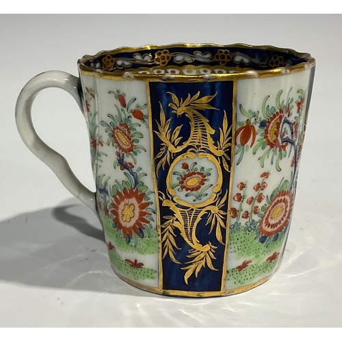 212 - A Worcester fluted teacup and saucer, painted with panels of colourful flowers on a green ground, bl... 