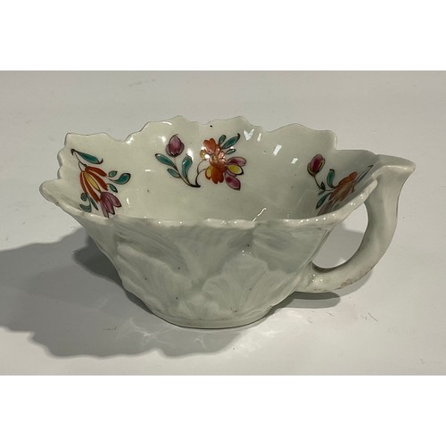 203 - A Worcester butter boat, moulded with overlapping geranium leaves, the interior painted with polychr... 