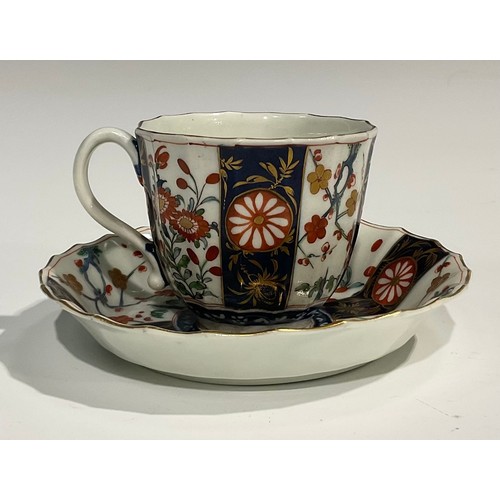 219 - A Worcester Rich Queen's pattern fluted coffee cup and saucer, scroll handle, decorated with alterna... 