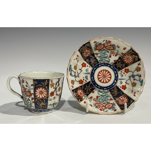 219 - A Worcester Rich Queen's pattern fluted coffee cup and saucer, scroll handle, decorated with alterna... 