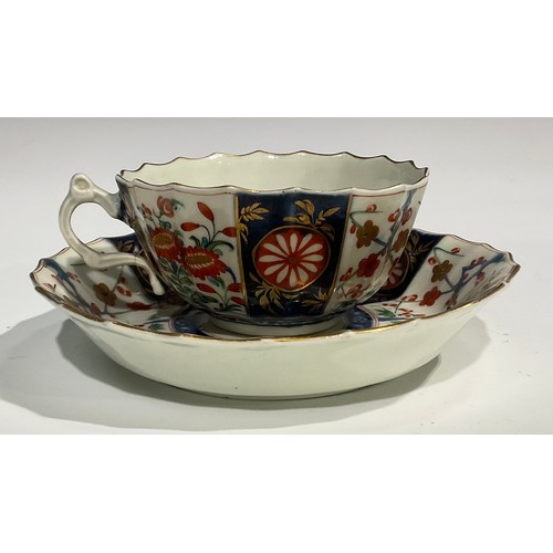 219 - A Worcester Rich Queen's pattern fluted coffee cup and saucer, scroll handle, decorated with alterna... 