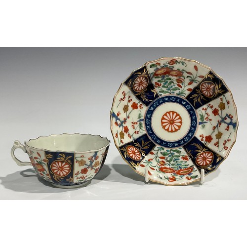 219 - A Worcester Rich Queen's pattern fluted coffee cup and saucer, scroll handle, decorated with alterna... 