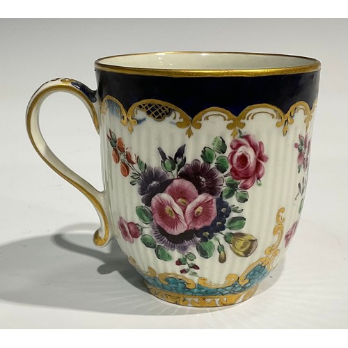 211 - A Worcester fluted teacup and saucer, circular cartouches painted with lakeside scenes, edged with a... 