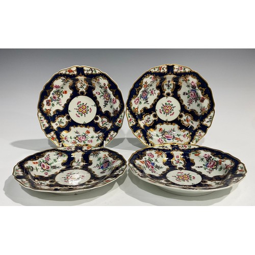 202 - A set of four Worcester shaped circular plates, painted with flowers and sprigs within gilt fan and ... 