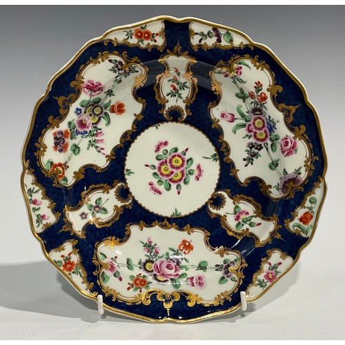 202 - A set of four Worcester shaped circular plates, painted with flowers and sprigs within gilt fan and ... 