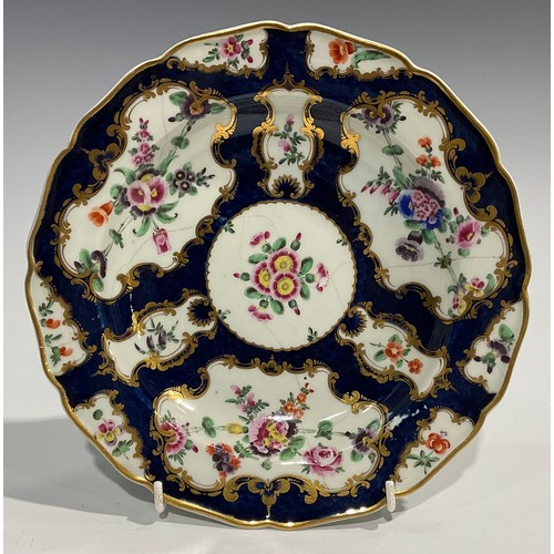 202 - A set of four Worcester shaped circular plates, painted with flowers and sprigs within gilt fan and ... 