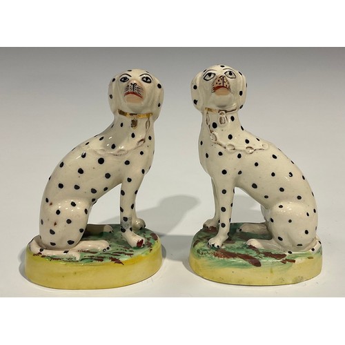 333 - A pair of Staffordshire Dalmations, seated to the left and right, gilt collars and chains, oval moss... 