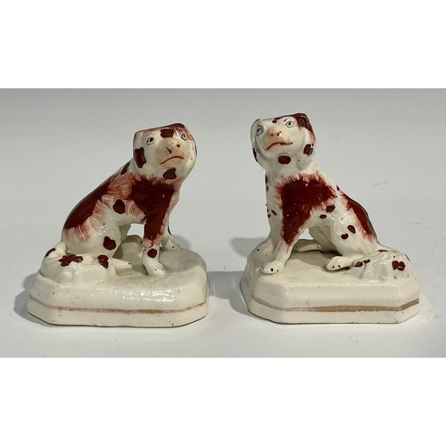 334 - A pair of Staffordshire Spaniels, seated to the left and right, picked out in rust brown, gilt lined... 