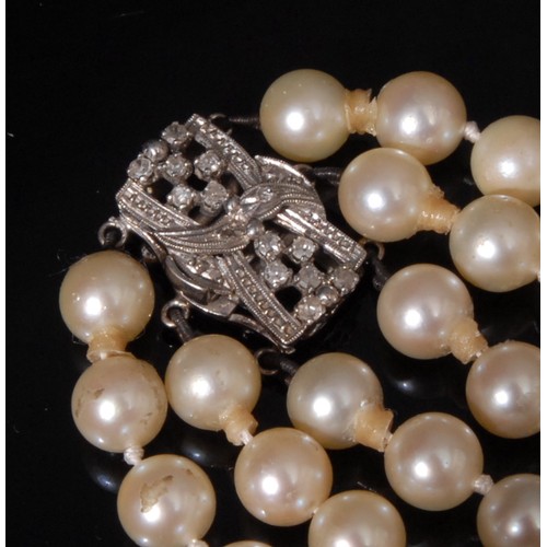 1448 - A three strand cultured pearl necklace, each pearl 7.5-8mm diameter, diamond set white metal clasp, ... 