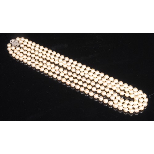 1448 - A three strand cultured pearl necklace, each pearl 7.5-8mm diameter, diamond set white metal clasp, ... 