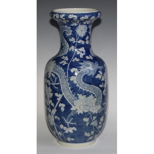 443 - A large Chinese ovoid vase, painted in tones of underglaze blue with dragons amongst flowers and fol... 