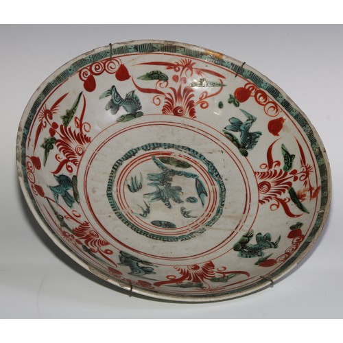 409 - A Chinese Swatow circular dish or charger, painted in tones of green and iron red with fish and scro... 