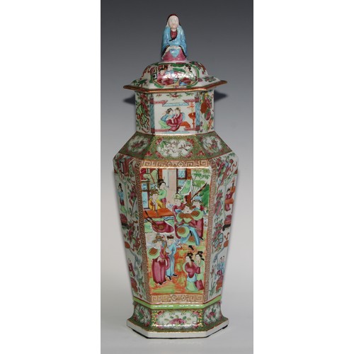 455 - A pair of Chinese famille rose hexagonal vases and covers, painted in the typical Cantonese manner w... 