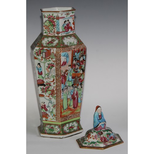 455 - A pair of Chinese famille rose hexagonal vases and covers, painted in the typical Cantonese manner w... 