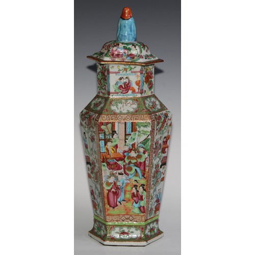 455 - A pair of Chinese famille rose hexagonal vases and covers, painted in the typical Cantonese manner w... 