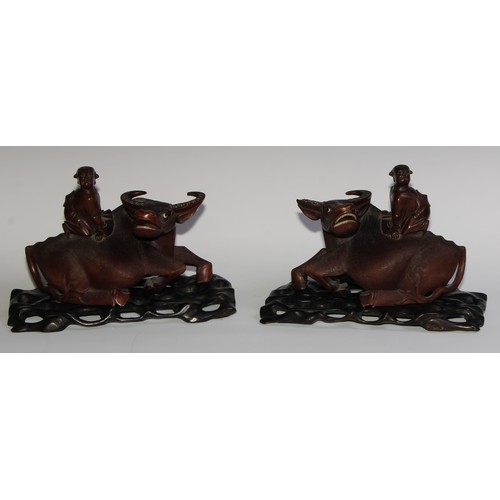 425 - A pair of Chinese hardwood carvings, of boys riding buffalo, glass eyes, bone teeth, carved bases, 3... 