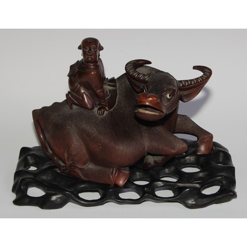 425 - A pair of Chinese hardwood carvings, of boys riding buffalo, glass eyes, bone teeth, carved bases, 3... 