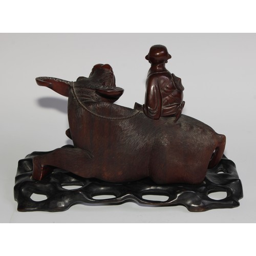 425 - A pair of Chinese hardwood carvings, of boys riding buffalo, glass eyes, bone teeth, carved bases, 3... 