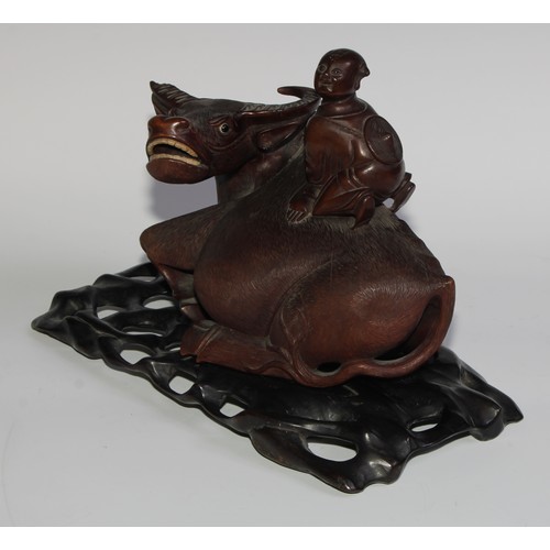 425 - A pair of Chinese hardwood carvings, of boys riding buffalo, glass eyes, bone teeth, carved bases, 3... 