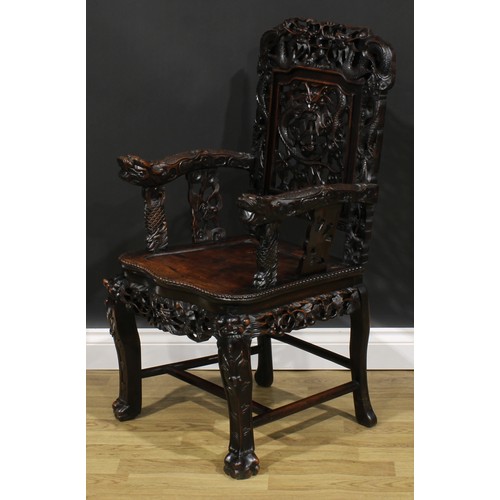 1650 - A Chinese hardwood armchair, carved throughout with dragons, serpentine seat with beaded border, cab... 