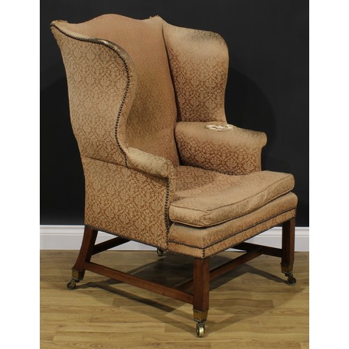 2045 - A George III wing chair, stuffed-over upholstery, squab cushion, internally chamfered legs, brass ca... 