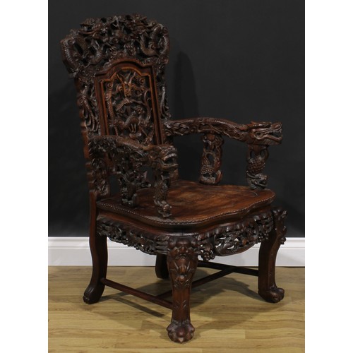 1863 - A pair of Chinese hongmu armchairs, carved throughout with dragons and stylised clouds, serpentine s... 