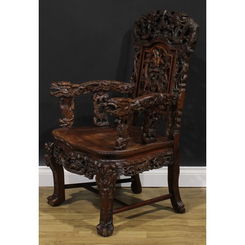 1863 - A pair of Chinese hongmu armchairs, carved throughout with dragons and stylised clouds, serpentine s... 