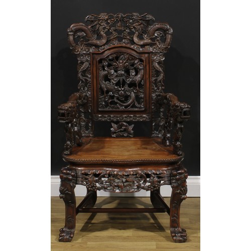 1863 - A pair of Chinese hongmu armchairs, carved throughout with dragons and stylised clouds, serpentine s... 